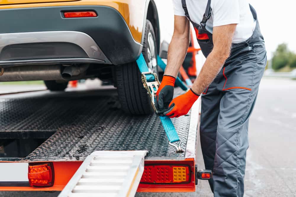 Handsome senior man working in bus towing service on the road. Roadside assistance concept.